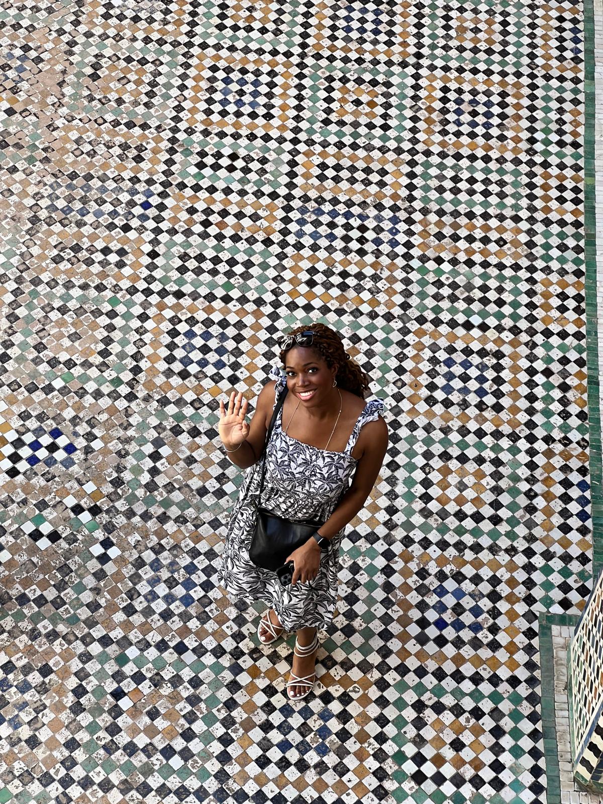 Oye standing on an intricately patterned tiled floor.