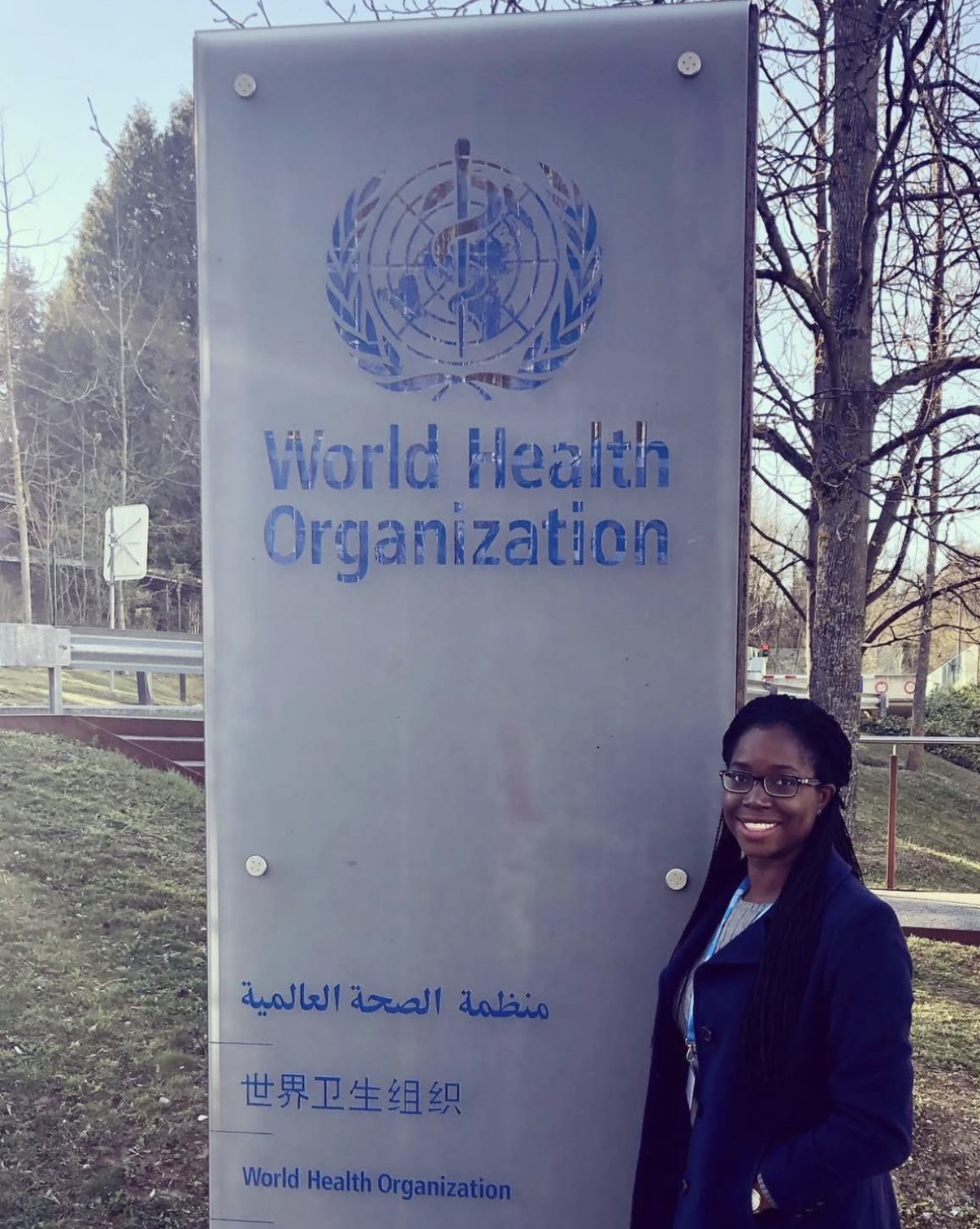 Dr. Oye E. Imoisili beside a World Health Organization sign