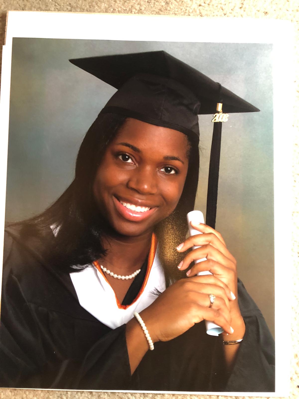 Oye smiling in graduation attire, 2008